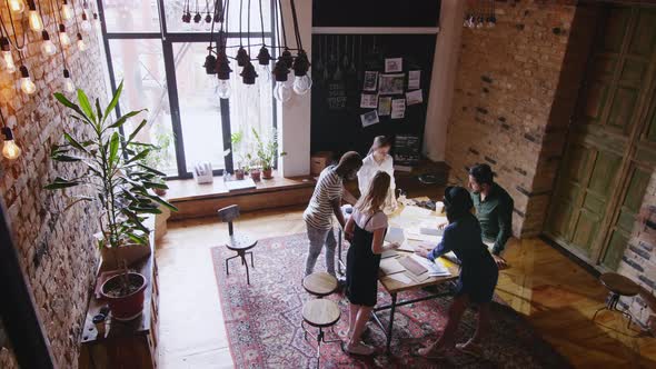 Diverse Team of Designers Discussing Sketches in Studio