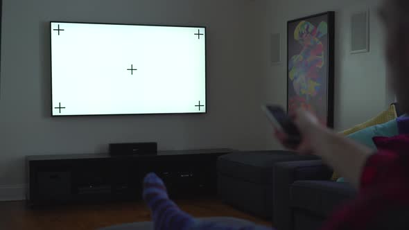 Dolly Shot of a Man Holding a TV Remote alt