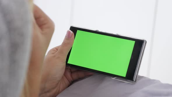 Blonde female relaxing on green screen display gadget 4K 2160p 30fps UltraHD footage - Young woman a alt