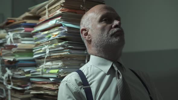 Depressed stressed businessman with lots of paperwork