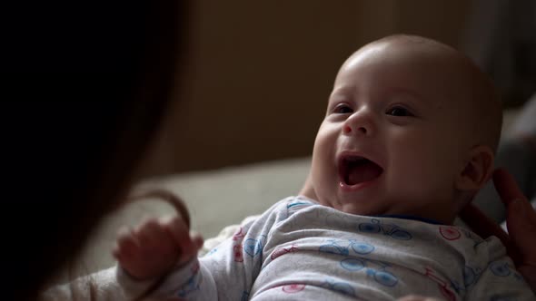 Newborn Baby With Young Mom Look Into Each Other Eye alt