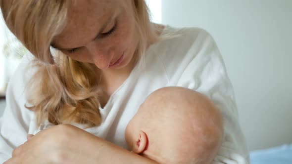 mom holds the baby in her arms and kisses him