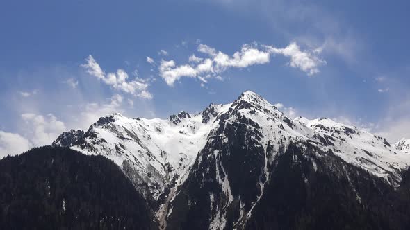 Treeless and Snowy Hill at Top of The Forested Mountain in Spring alt