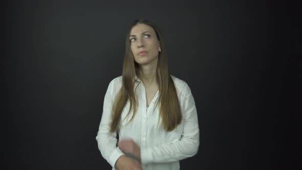 Lady with Serious Face Crosses Hands Under Electric Light alt