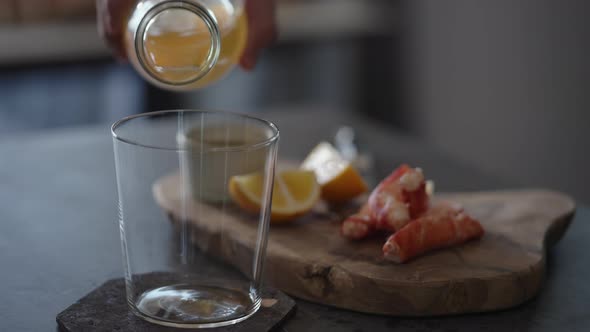 Pour Ginger Beer in Tumbler Glass with Crab Legs on Background alt