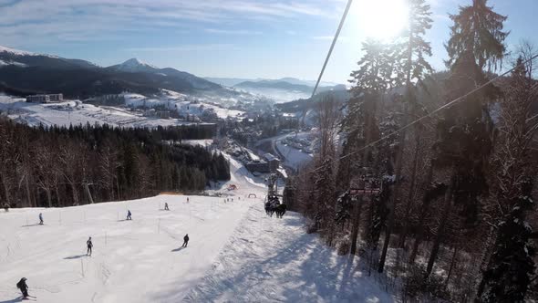 POV From Ski Chair Lift To Snowy Ski Slope, Skiers Slide on Ski Slope.Ski Resort alt