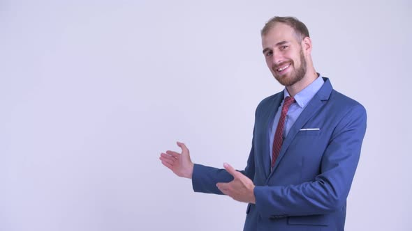 Happy Bearded Businessman Showing Something To the Back alt
