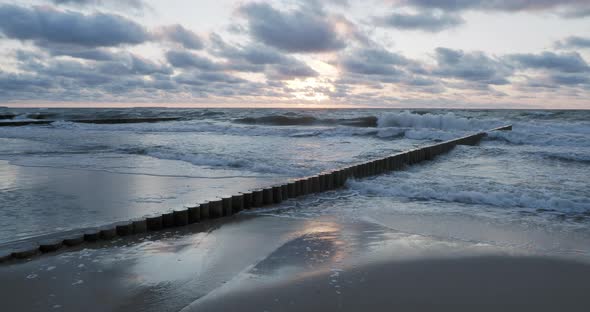 Breakwater of Larch Logs. Strengthening the Seashore To Keep the Sand on the Beach. Gorgeous Sunset alt