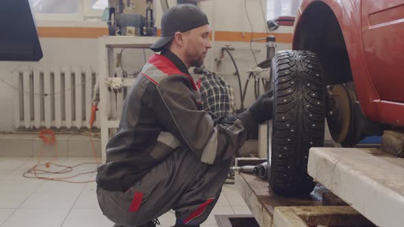 Mechanic Changing Car Tire alt