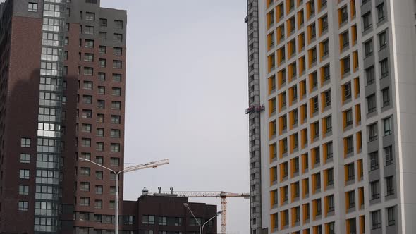 Highrise Builders Being at a Height in a Cradle are Building a Modern House alt