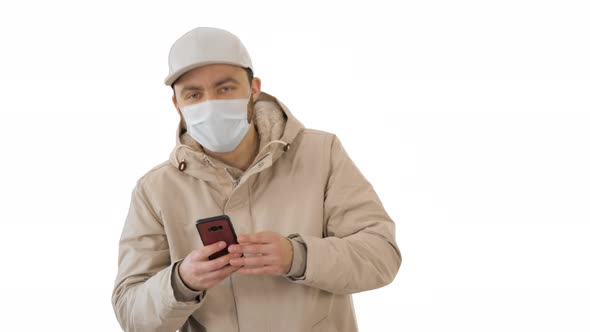 Young Casual Man Walking Making a Call Wearing Warm Clothes and Protective Mask on White Background. alt