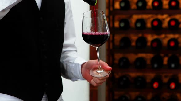 Male waiter pouring wine into wine glasses 4k alt