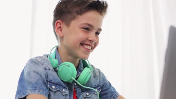 Boy with Headphones Having Video Chat on Laptop alt