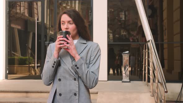 Pretty Caucasian Woman Drinking Coffee on the Street alt