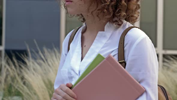 Teenage Girl Student Goes to School After Summer Vacation Holding Books and Notebooks