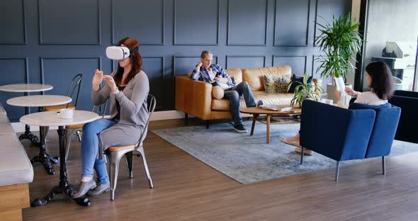 Businesswoman using virtual reality headset in the lobby at office 4k