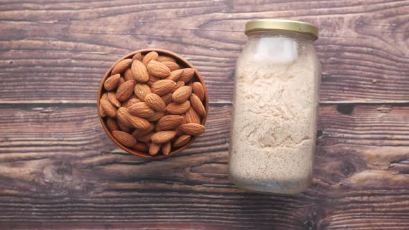 Almond Powder and Almond in a Jar on Table alt