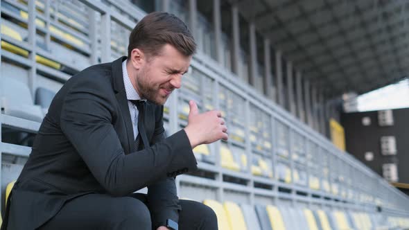 An Office Worker Has a Headache He is Sitting on a City Street alt