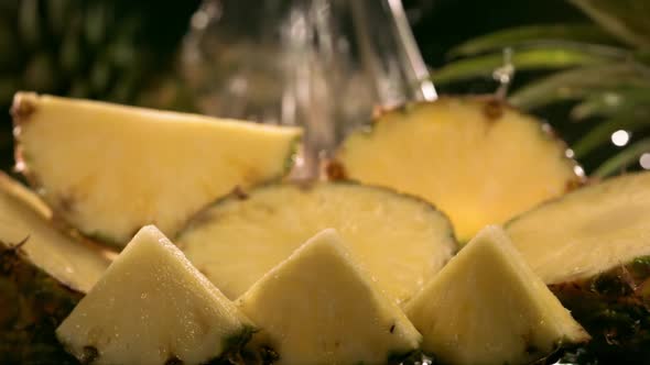 Slow Motion Shot of Pineapple and Water Splashing Through Pineapple Slices alt
