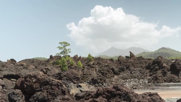 Clouds formation timelapse over Pico Del Teide volcano and lava rocks in foreground alt