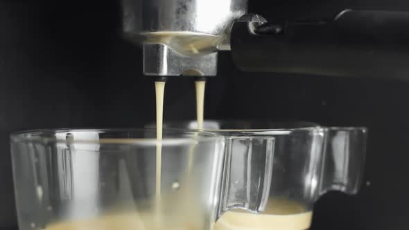 Making an Esspresso Using Proffesional Coffee Machine on a Black Background alt