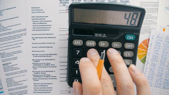 Businessman Analyzing The Market And Considers On The Calculator