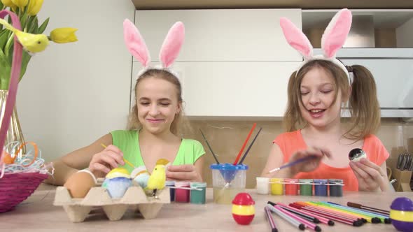 Two Sisters Together Decorate Easter Eggs with Colors Talk and Laugh