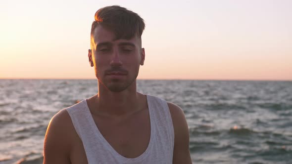 Portrait of Young Man on Concrete Pier with Rough Ocean Background Slow Motion alt
