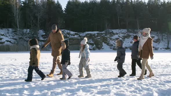 Happy Family Hiking Across Frozen Lake alt