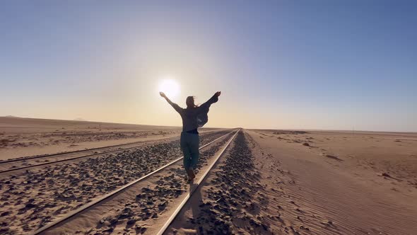 Young Woman Walks at Abandoned Railway Near Garub Railroad Station alt