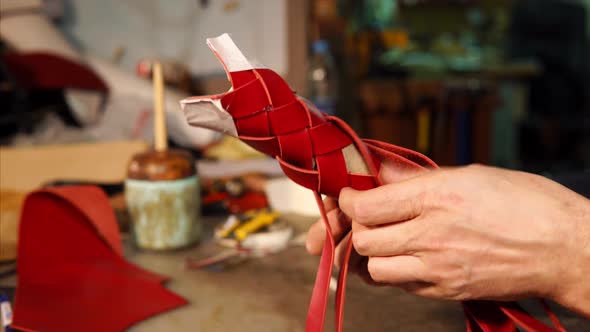 Master Is Interlacing Red Leather Bands Cylinder Casing in Craft Workshop alt