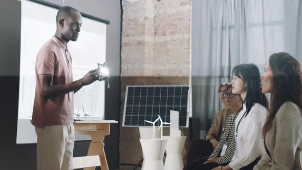 African American Man Presenting Solar Charger on Conference alt