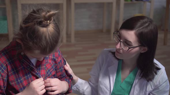 Dramatic Shot of a Sick Child and a Doctor in a White Coat Talking To a Patient of the Clinic alt