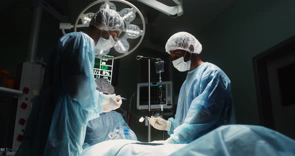 A Team of Surgeons Perform an Operation in a Bright Operating Room alt