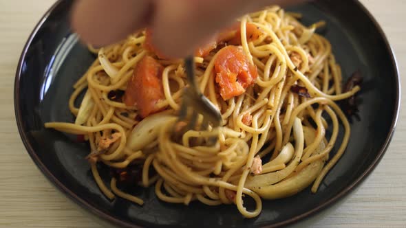 fork rolling stir-fried spaghetti with salmon and dried chilli - fusion food style alt