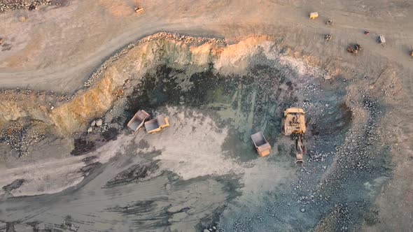 Excavator loading crushed stone into a dump truck in a crushed stone quarry alt