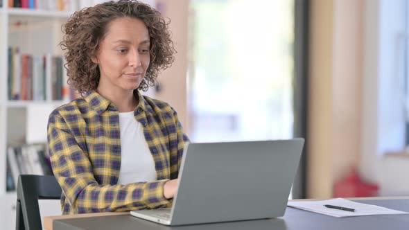 Attractive Young Mixed Race Woman with Laptop Pointing at Camera alt