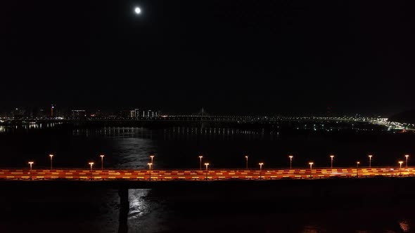 Night City Traffic on the Bridge Lunar Path Reflection Aerial View