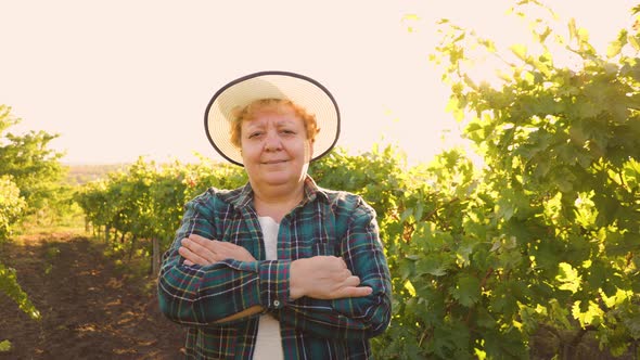 Old Woman with Hat on Her Head Female Farmer Looking at Camera alt