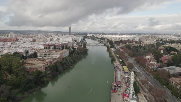 Panoramic cityscape from over Guadalquivir river of Seville, Spain; drone