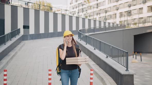Caucasian Young Female Courier Calling a Customer on the Phone alt