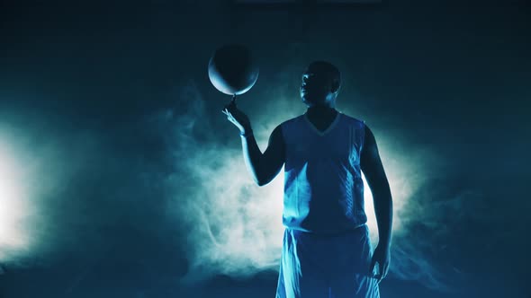 Male Player is Spinning a Basketball on His Finger alt