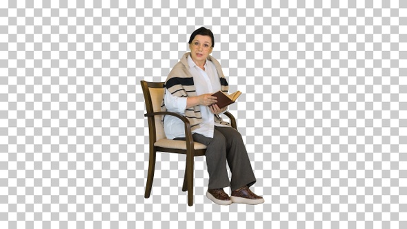 Happy senior woman reading a book aloud on camera, Alpha Channel alt