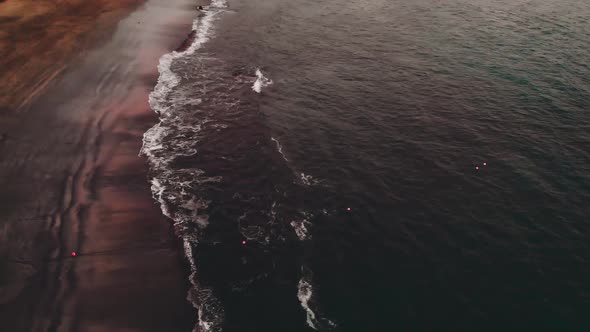 Aerial View of a Black Beach with Volcanic Sand, a Multi-colored Beach - Black, Red, Orange