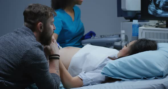 Doctor Examining Pregnant Woman with Ultrasound alt