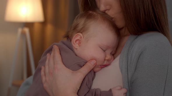 Loving Mother Kissing Adorable Newborn Baby Sleeping On Her Chest alt