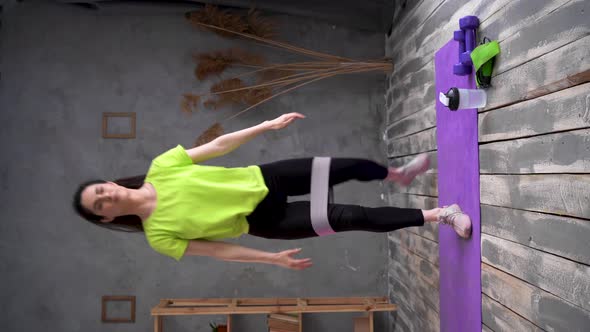 Sporty Woman Making Squats Using Stretching Strap She is Training at Home alt