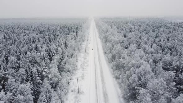 Aerial Top View From Drone Birds Eye View of Winter Landscape and Snowy Ice Road Car Moving on Area