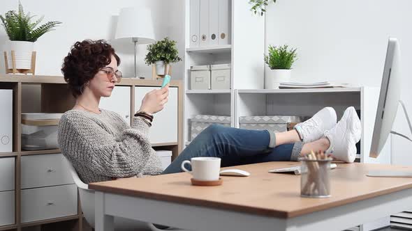 Young Woman Procrastinates Scrolling her Smartphone alt