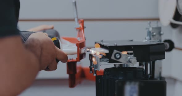 Sharpening an Ice Skate on Equipment, Sparks Fly. Blade of an Ice Skate Is Sharpened on a Machine alt